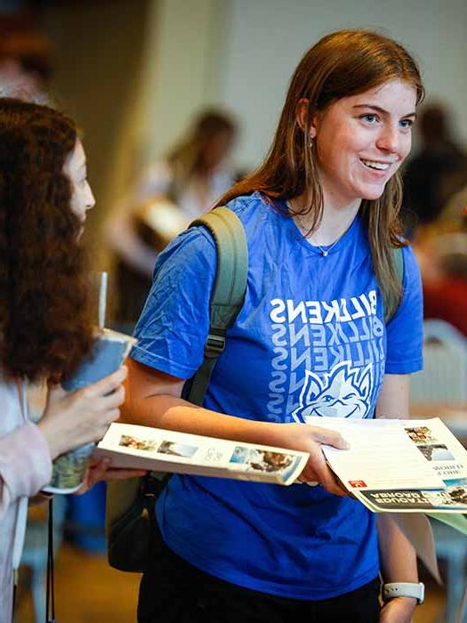 Student smiling while having a conversation with other students